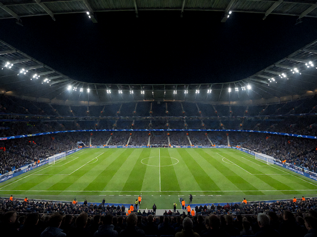 夜晚灯光下的足球体育场全景，绿茵赛场与看台灯光交相辉映